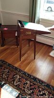Wide angle of antique traveler's desk with fold-over top and removable tapered legs