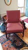 Front view of upholstered armchair showing fabric and wooden frame