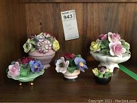 Five bone china floral arrangements displayed on a wooden surface with a tag reading 'Bone China'