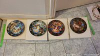 Four Bradford Exchange Russian Series collectible plates with original boxes visible under each plate