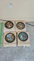 Four Bradford Exchange collectible plates from the Legend of the Snowmaiden series, each shown on top of their original boxes. Plates are round with colorful detailed illustrations and black decorative borders.
