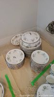 Stack of dinner plates, salad plates and tureen at center