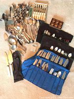 Overhead view of assorted silver-plated spoons and cutlery laid out on floor