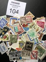 View of assorted used collectible stamps showing front faces with diverse designs, denominations, and countries of origin.