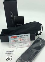 Box, carrying pouch, informational pamphlets and promotional Instagram contest card placed on a white background.