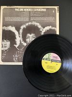 Photo showing back cover of album with band photo and track list along with vinyl record disc with Reprise label