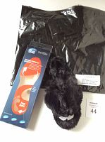 Photo showing the packaged gel insoles next to one of the black furry slippers with size tag 44 visible.