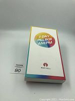 Front view of the sealed product box with '7 DAY PILLBOX AM/PM' and Bug Hull logo