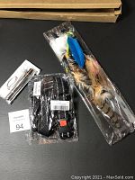 Lot with two feather teaser toys for cats, adjustable dog muzzle guard, and LED light pen, all in original plastic packaging.