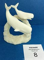 Front angle showing two white whales mounted on textured base