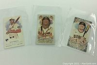 Three Topps 2021 Allen & Ginter baseball cards, each in a separate protective sleeve, showing players holding bats.