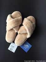 Top view of the pair of light beige fleece memory foam slippers showing plush criss-cross straps and soft cushioned insole, labeled size 43 European.