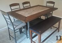 Front view of six-piece dining set including rectangular wood combination rustic style table, four chairs with gray cushions, and black cushioned bench.