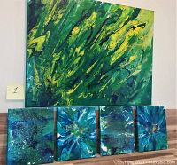 Large green and yellow abstract pouring technique oil on canvas with four smaller blue floral pouring technique canvases laid in front.