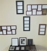 Overview of assorted picture frames hanging on wall and displayed on surface, showing variety of sizes and styles.