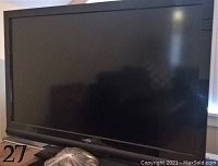 Photo of a Vizio TV with 42 inch screen and the remote control in front.