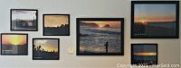 Wall display featuring the full set of five framed photographs depicting Pacific coast sunsets and dawns