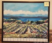 Photo of a framed watercolor painting showing a vineyard scene with hills and a water body in the background. The painting is signed NELL-REVEL-SMITH at the bottom and has a dark wooden frame.
