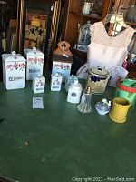 Full view of all ceramic canisters and spice jars arranged on a table, with background items excluded
