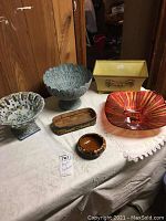 Lot of six containers on table including metal, glass, ceramic bowls, planter, and basket