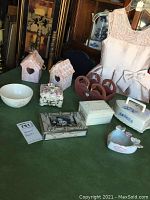 Full overview of all decorative boxes, bowls, and other items arranged on a table as seen in the lot