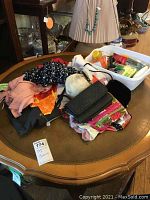 Overview of clothing items on table with a washbasin containing cleaning products.
