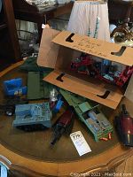 Overview of multiple Hasbro GI Joe toy tanks and accessories arranged on a table with cardboard box packaging.