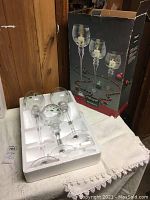 Three tall glass votive holders in white foam packaging, in original Pfaltzgraff Winterberry box with holiday theme graphics.