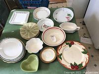 All items arranged on a table showing a variety of plates and bowls including heart-shaped and cutout square plates
