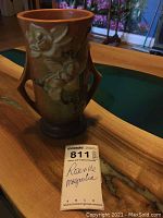 Front view showing Roseville Magnolia vase with distinctive raised magnolia flower details and two handles.