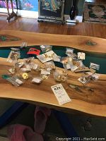 Wide shot of the table showing the large assortment of vintage screw back and clip on earrings scattered and some still in small plastic bags.
