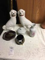 Full lot showing two white ceramic Stanford Shire dog statues, ceramic covered bowl, white floral vase, black gold decorative pot, and octagonal floral dish