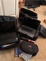 Overview: two open laptops, multiple closed cases, goLite pouch, red device, silver scale, manual
