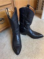 Front angled view of pair of black cowboy boots showing pointed toe and pull tabs with leather creasing