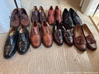 Group of seven pairs of men's dress shoes size 9.5, various brown and black leather, includes brogue wingtip and tassel loafers showing wear.