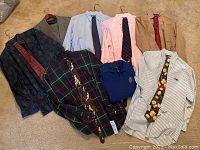 Photo showing full layout of shirts, ties, and suit pieces on carpeted floor