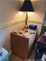 Wood file cabinet with two drawers for hanging files, corner view in office setting