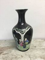Front view of gloss black vase with painted figures and tree under flared neck