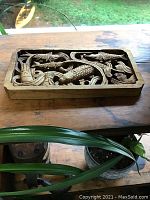 Front view of hand carved wood plaque showing detailed fish and aquatic plant motif.