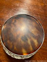 Top view of vanity jar lid showing brown mottled pattern.