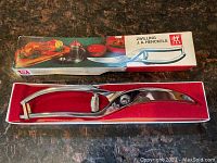 Two vintage stainless steel poultry shears in original Zwilling J.A. Henckels boxes on countertop.