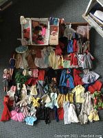 Overall view of vintage Barbie dolls with numerous clothing pieces spread out around them
