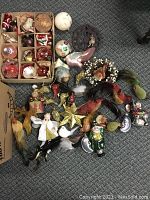 Overview of multiple vintage Christmas decorations including box of ball ornaments, birds, angels, and star ornaments.