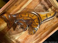 Top view of the carved whale showing detailed Native style patterning on cedar wood.