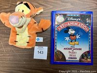 Photo showing vintage Tigger hand puppet on the left and Disney's Art of Animation book on the right.