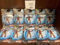 Front view of all 10 Iron Man figures in blister card packaging arranged in two rows of five, showing Avengers branding and age recommendation on packaging.