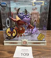 Front view of original boxed set showing Johnny and Randy figures on a collectible base with background art and visible Disney Store and Monsters University branding.