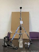 Front view of Pearl high hat stand, drum foot pedal, two Shure microphones on a table