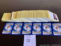 Long stack of Pokémon card edges and eight card backs laid in front