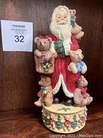 Front view of Santa Claus musical figurine holding teddy bears with Christmas themed base